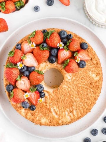 overhead shot of baked angel food cake topped with fresh berries