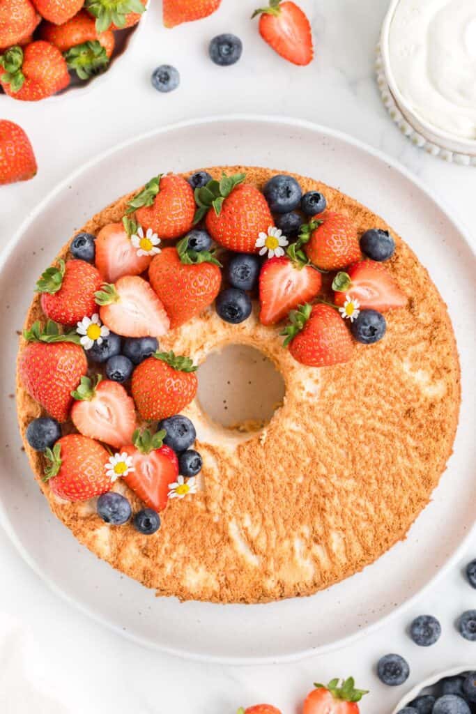 overhead shot of baked angel food cake topped with fresh berries 