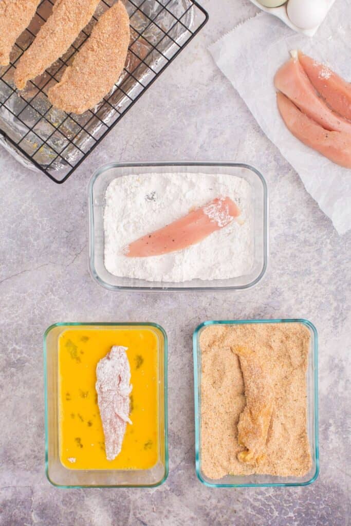 a chicken tender in each a bowl of flour, egg, and breading.