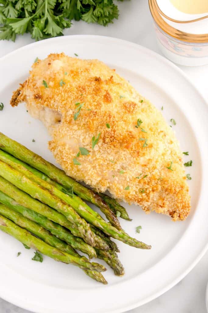 baked chicken cordon bleu with roasted asparagus on a white plate