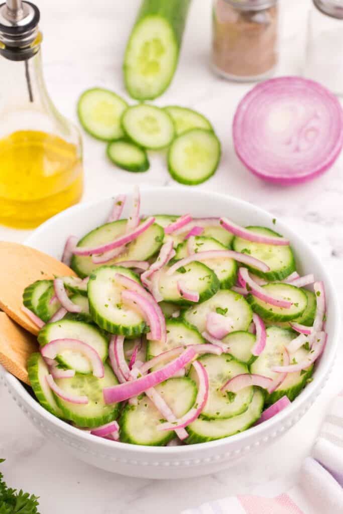 tossing cucumber slices and onions in vinegar dressing