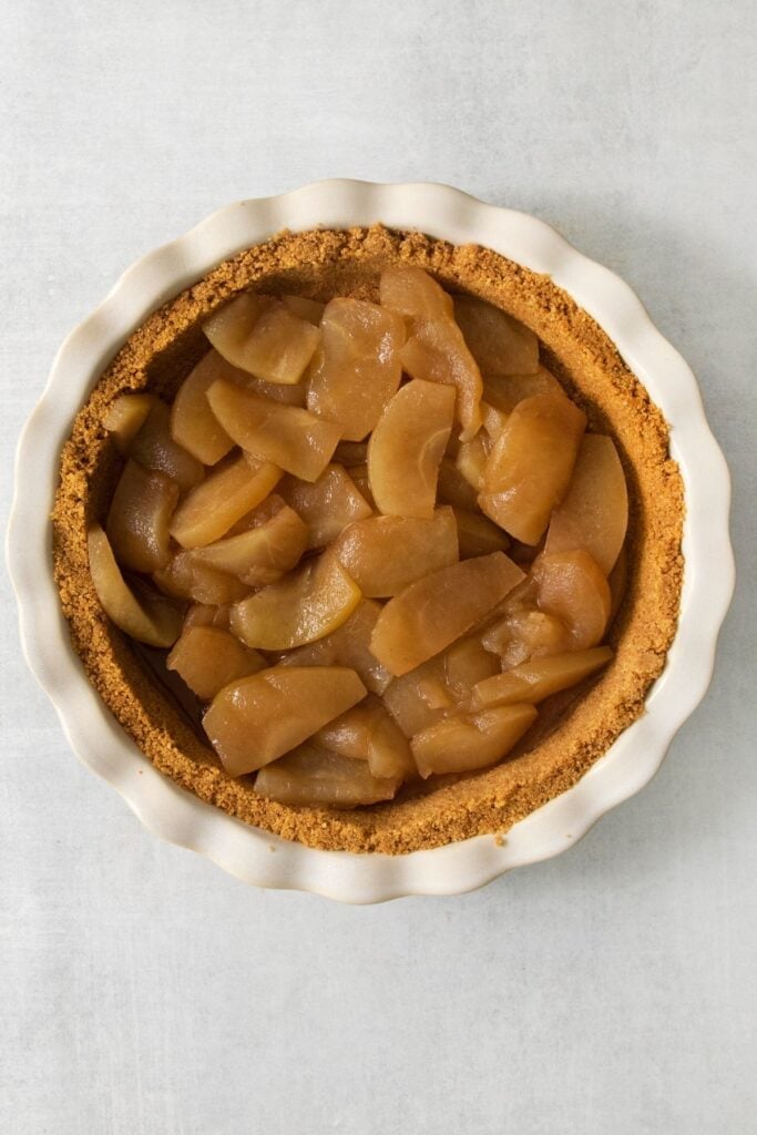Apples placed evenly into the graham cracker crust.