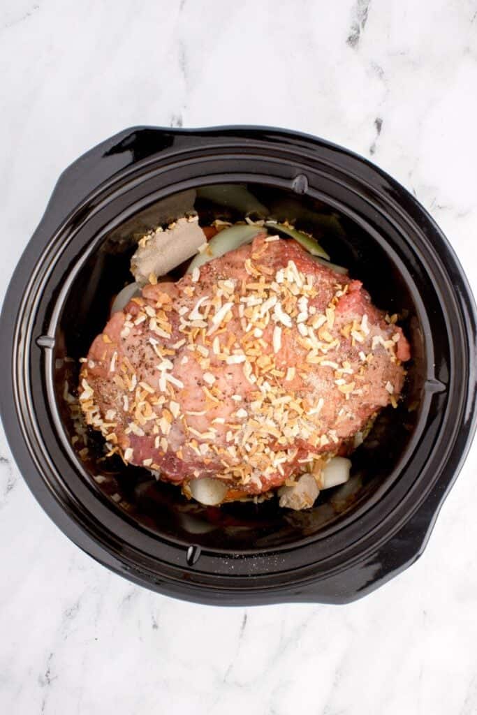 Raw sirloin tip roast in the crock pot with veggies.