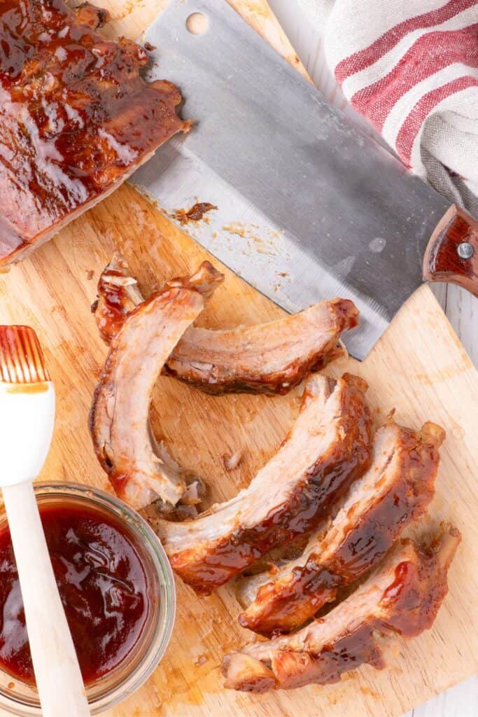 individual pork riblets on a wooden cutting board