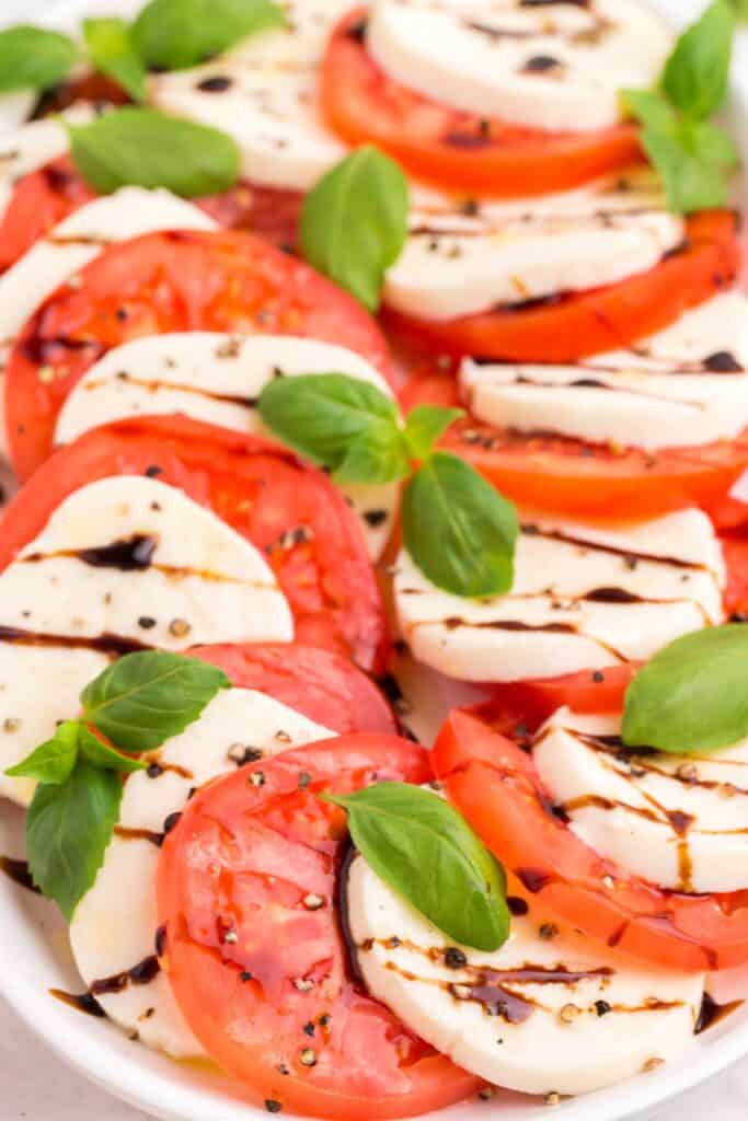add fresh basil leaves to tomato caprese salad