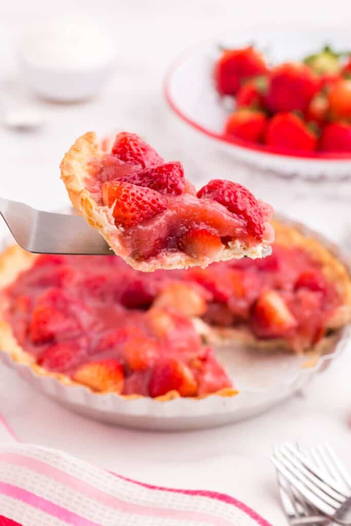 cutting out a slice of fresh strawberry pie with a pie knife