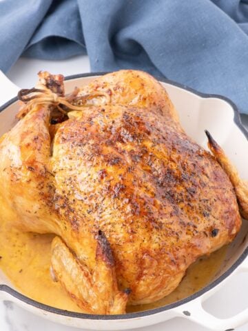 oven roasted chicken in a white cast iron skillet