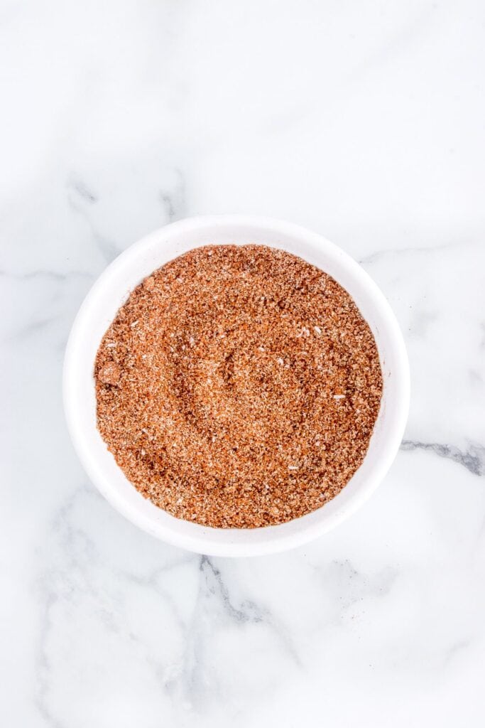 mixing homemade dry rub in a small white bowl 