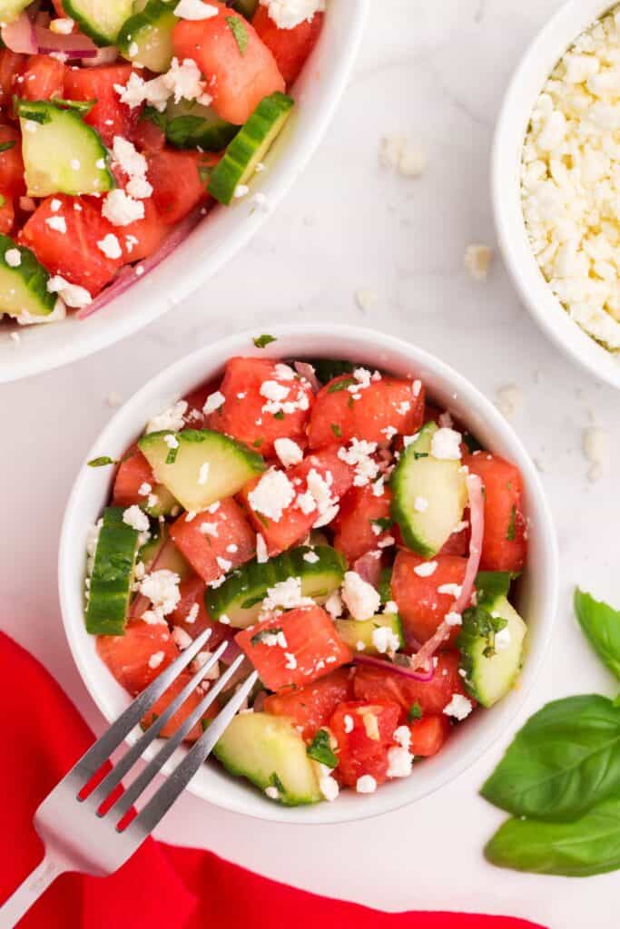watermelon cucumber feta salad served with a fork 