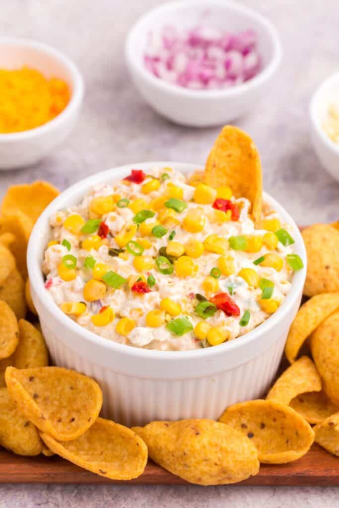 a bowl of fiesta corn dip with scoopable Frito chips 