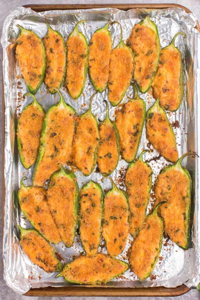 Baked jalapeno poppers right out of the oven with a golden brown top.