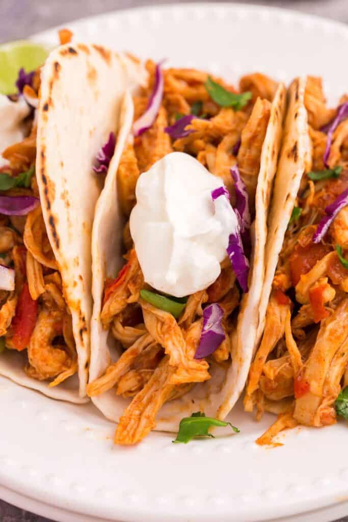shredded chicken taco with flour tortillas and sour cream 