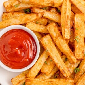 Air fryer fries on a white plate with ketchup.
