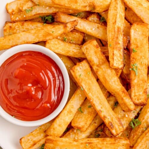 Air fryer fries on a white plate with ketchup.