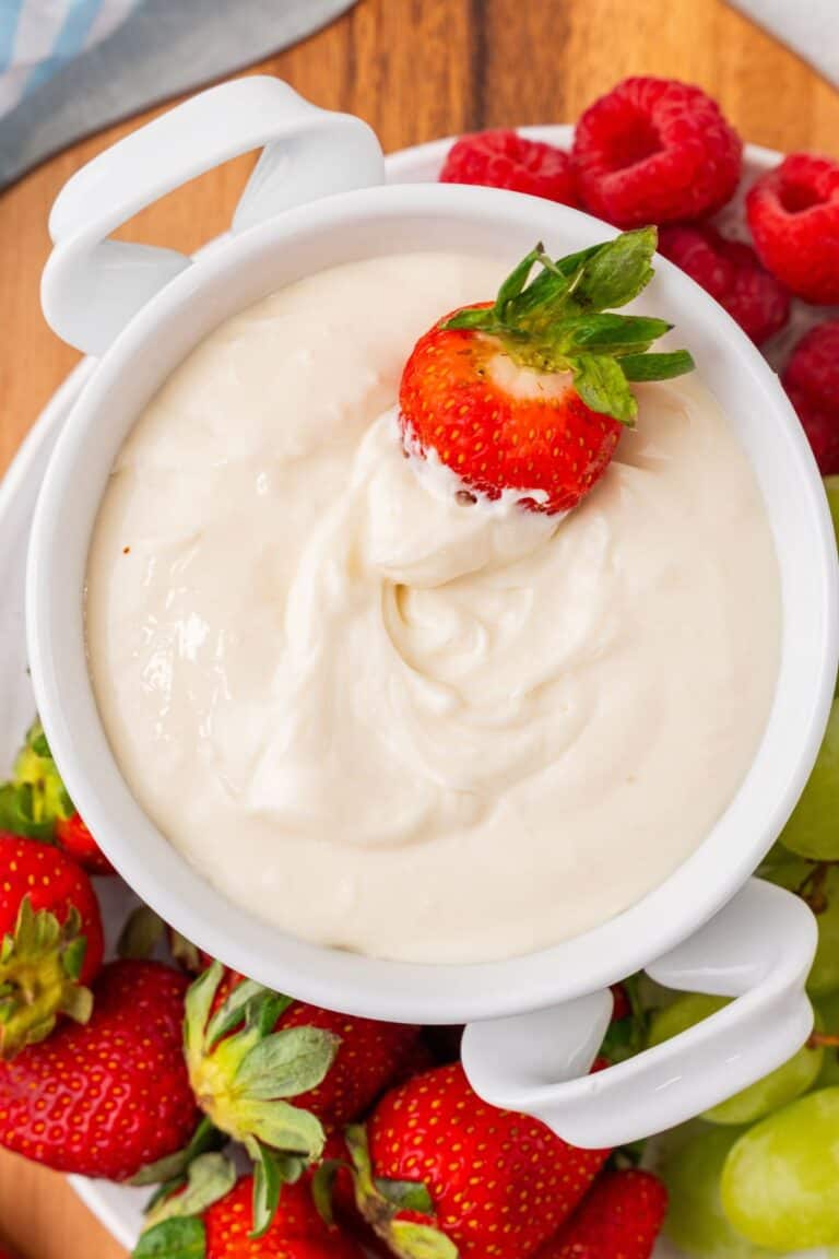 Cream cheese fruit dip with a strawberry dipped into it.