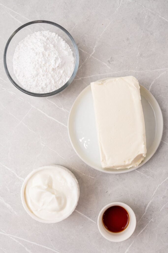 Ingredients needed to make cream cheese fruit dip: cream cheese, Greek yogurt, powdered sugar, and vanilla.