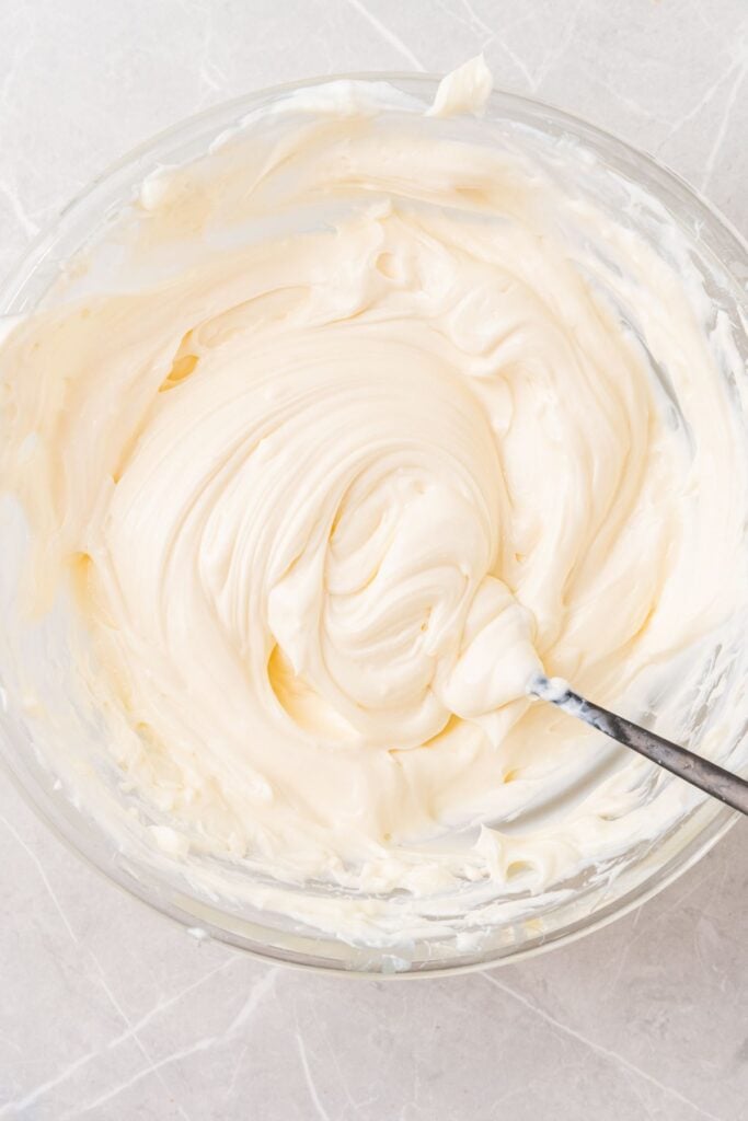 Fruit dip with cream cheese being whipped in a bowl.