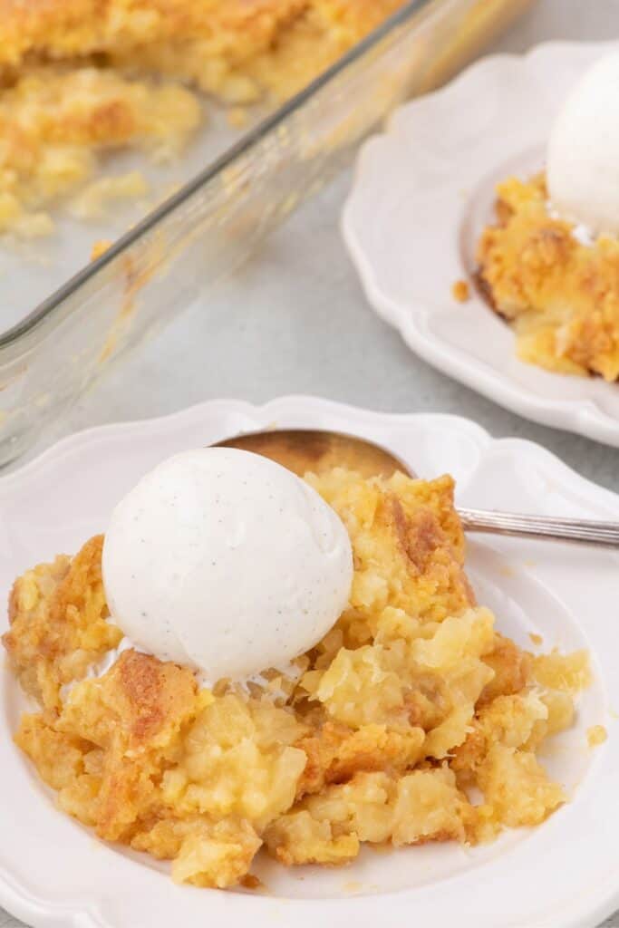 Pineapple cake served on a white plate with vanilla ice cream.