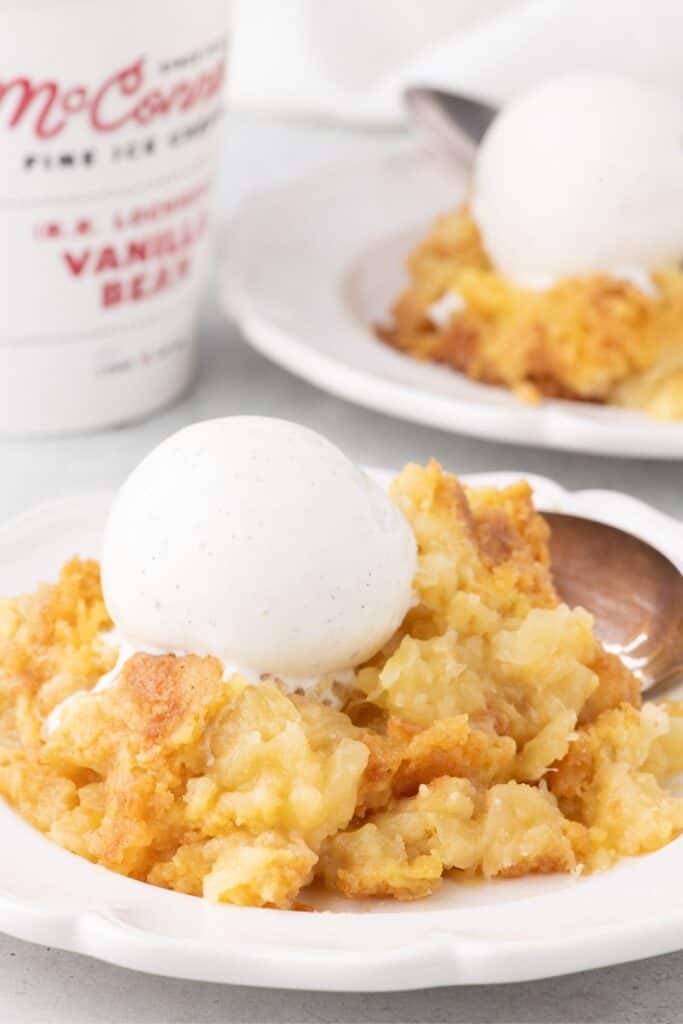 Dump Cake with pineapple on a plate with vanilla ice cream. 