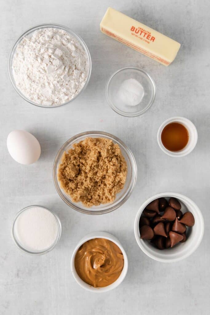 Ingredients needed to make peanut butter kiss cookies: butter, peanut butter, brown sugar, sugar, egg, vanilla, flour, baking soda, and hershey kisses.