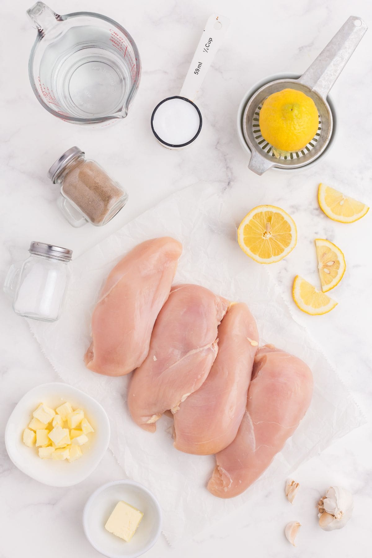 Ingredients needed to make lemon chicken: chicken breasts, butter, salt, pepper, garlic, lemons, sea salt, and water.