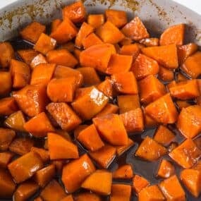 Candied yams in a skillet on the stove.