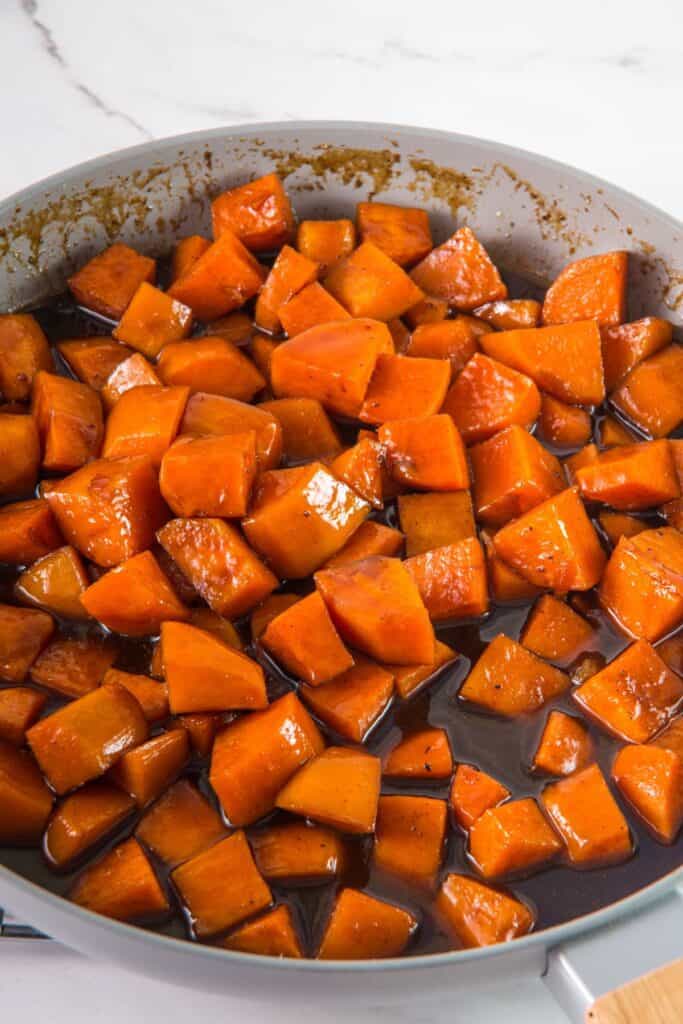 Candied yams in a skillet on the stove.