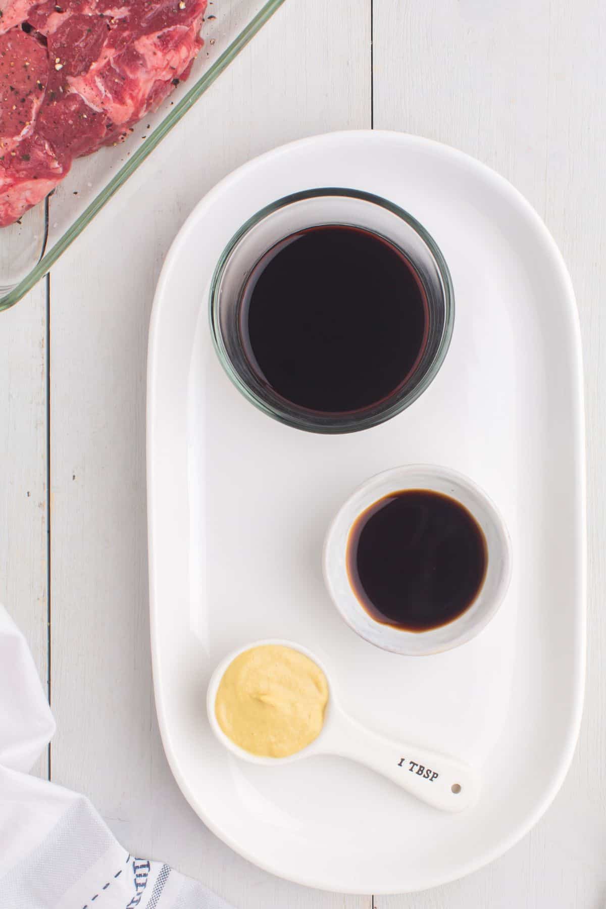Ingredients needed to make steak marinade: soy sauce, worcestershire sauce, and dijon mustard.