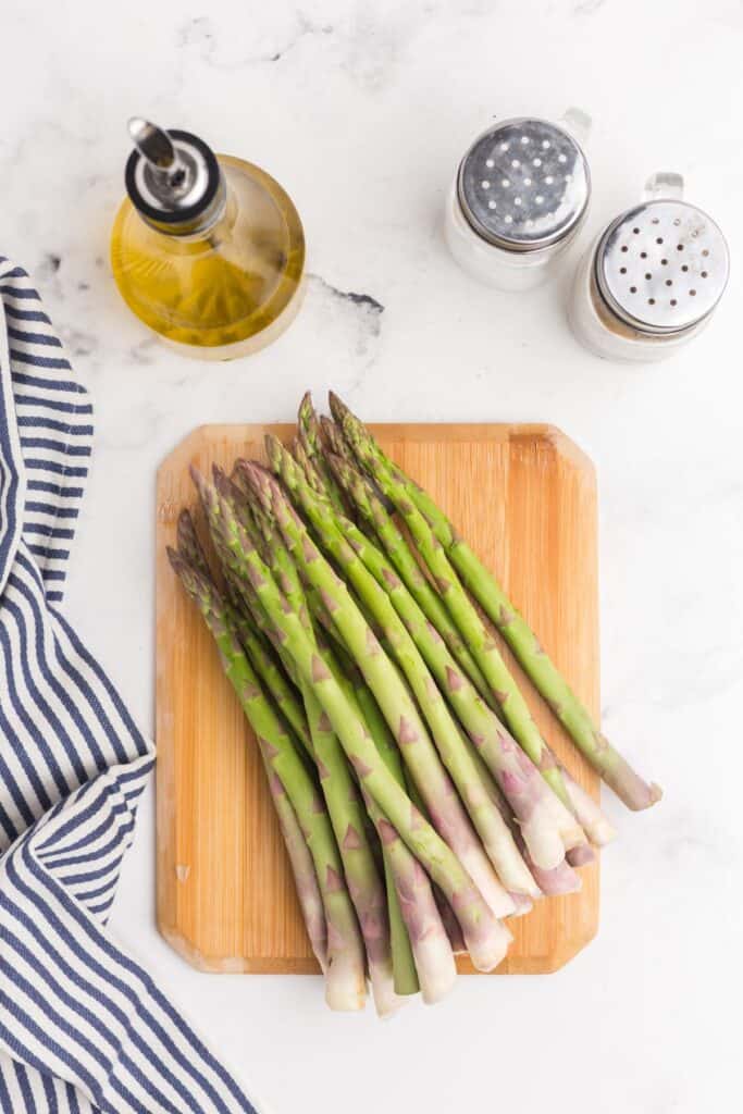 Ingredients for roasted asparagus: fresh asparagus spears, salt, pepper, and olive oil.