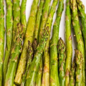 White serving plate with roasted asparagus.
