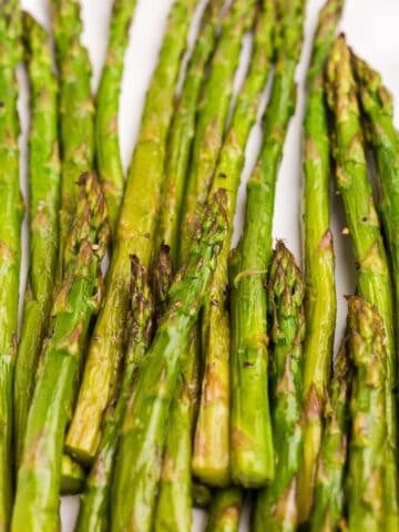 White serving plate with roasted asparagus.