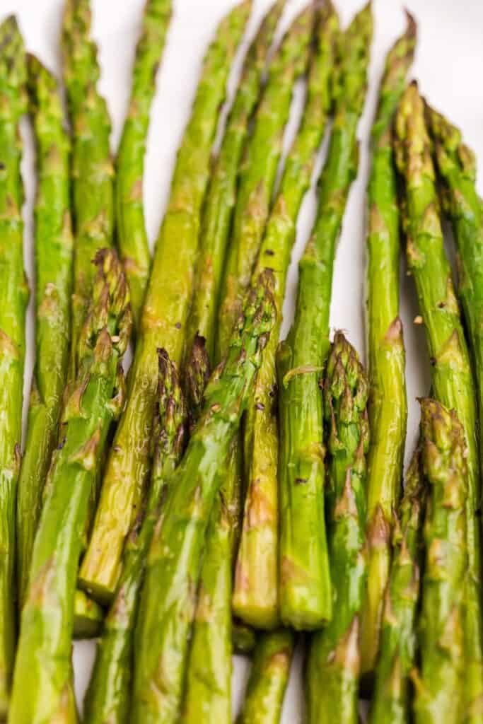 White serving plate with roasted asparagus.