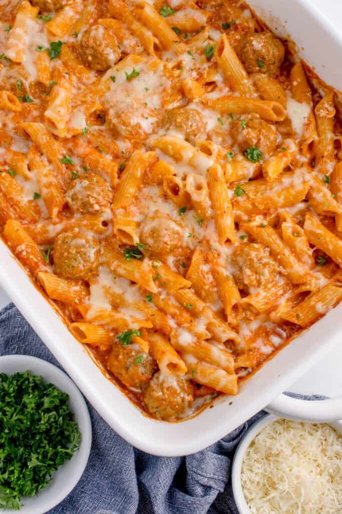 Completed baked penne pasta in a white baking dish.
