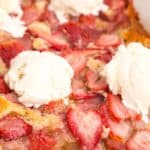Close up view of strawberry cobbler in a baking dish.
