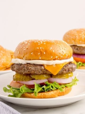 Bison burgers on white dinner plates.