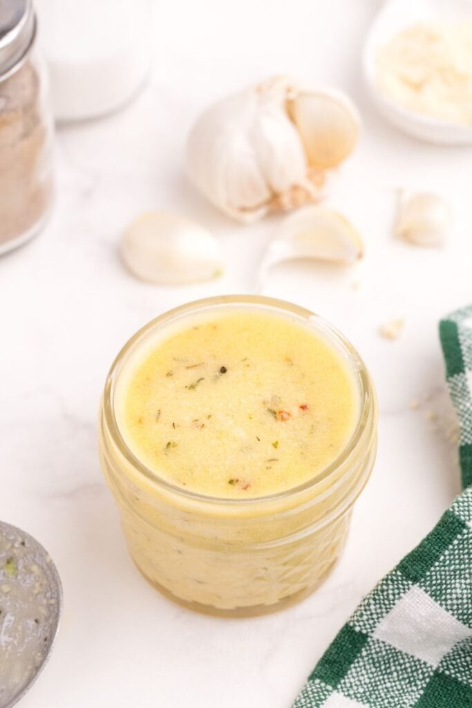 A glass jar of homemade garlic parmesan sauce.