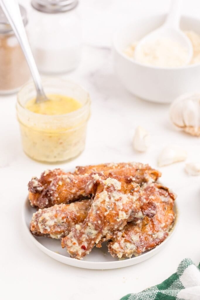 Wing sauce brushed over a plate of chicken wings.