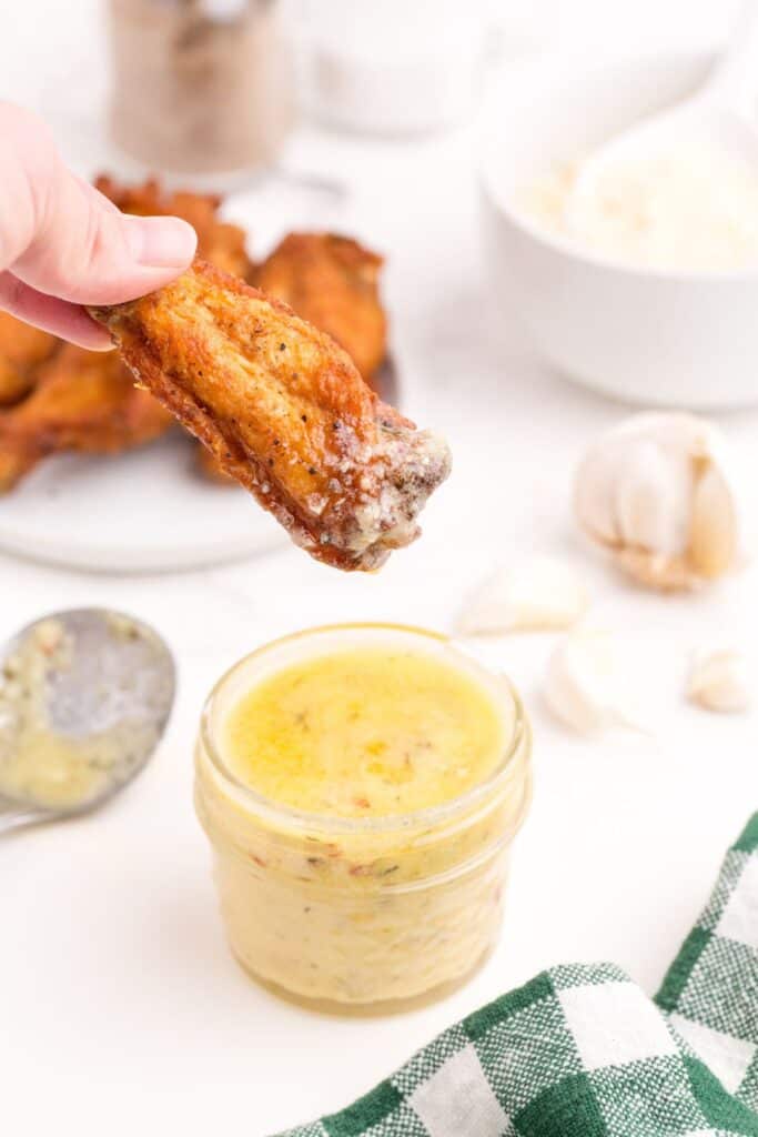 A chicken wing dipped in garlic parmesan sauce.