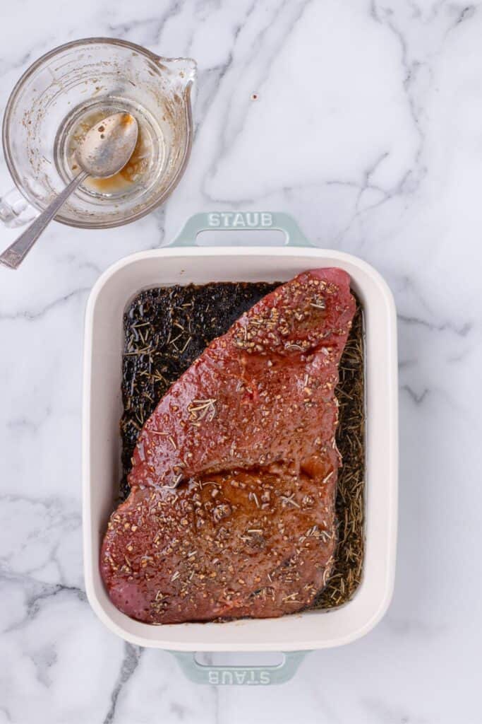 London broil in a baking pan with a marinade.