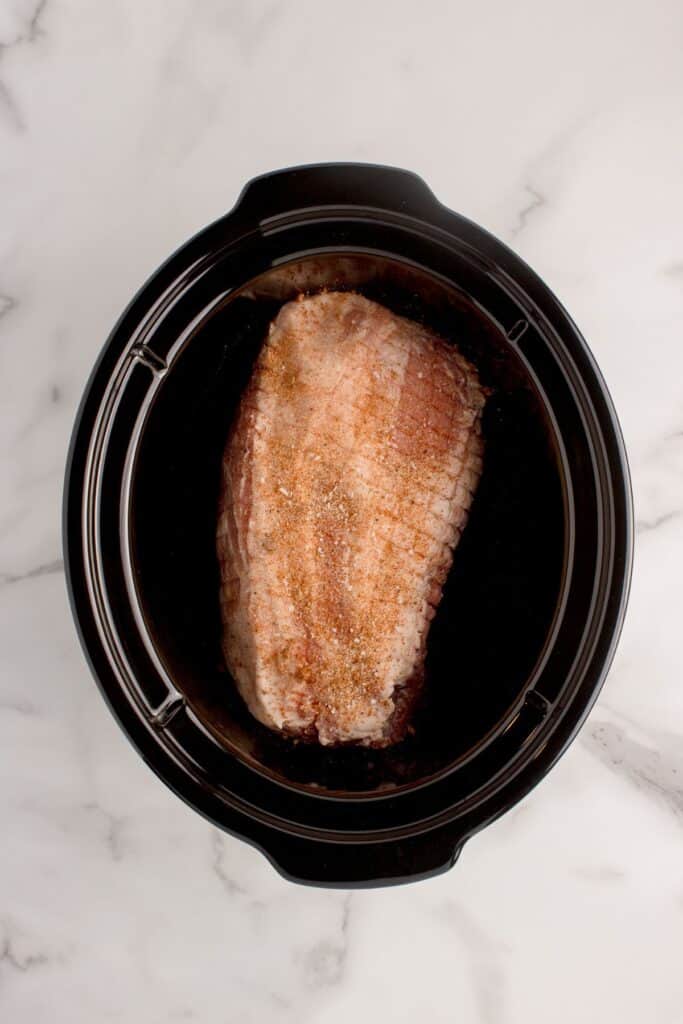 Raw pork roast in the crock pot insert.