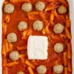 baked penne pasta in a casserole dish about to be put in the oven.