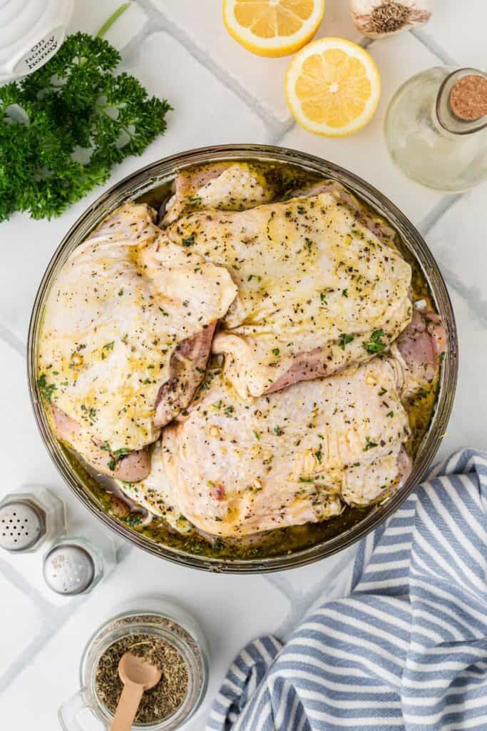 Marinated chicken thighs in a bowl.