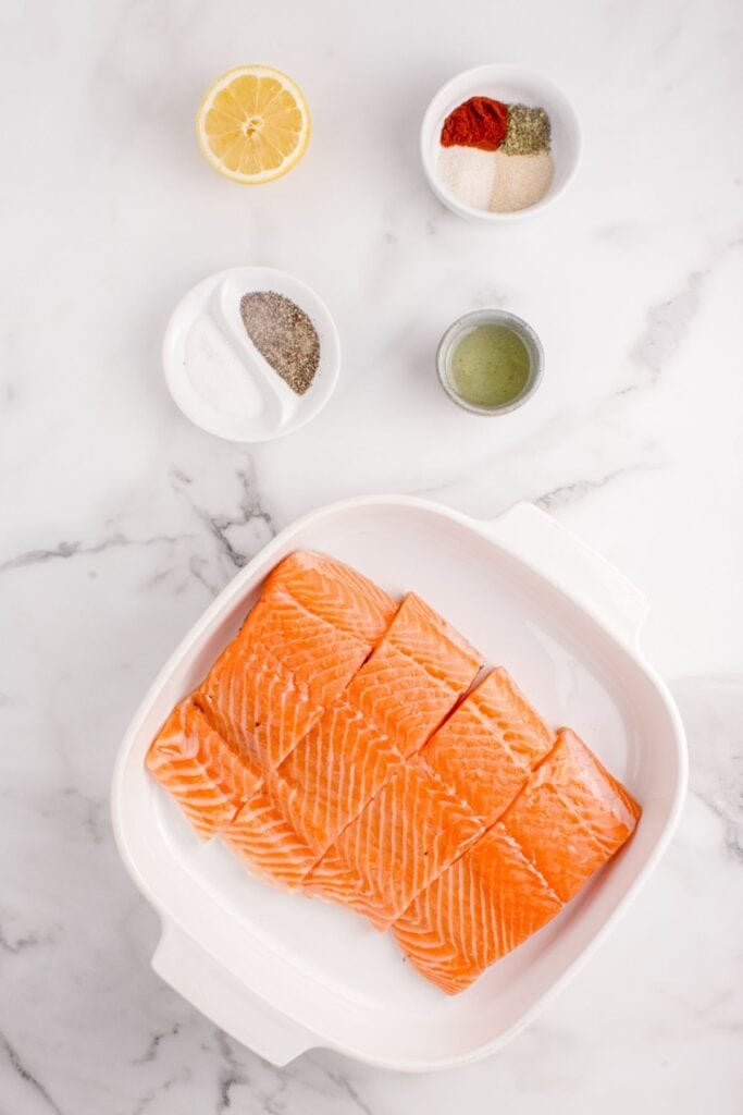 Ingredients for baked salmon: salmon fillets, onion powder, garlic powder, Italian seasoning, paprika, salt, black pepper, olive oil, and lemon juice.