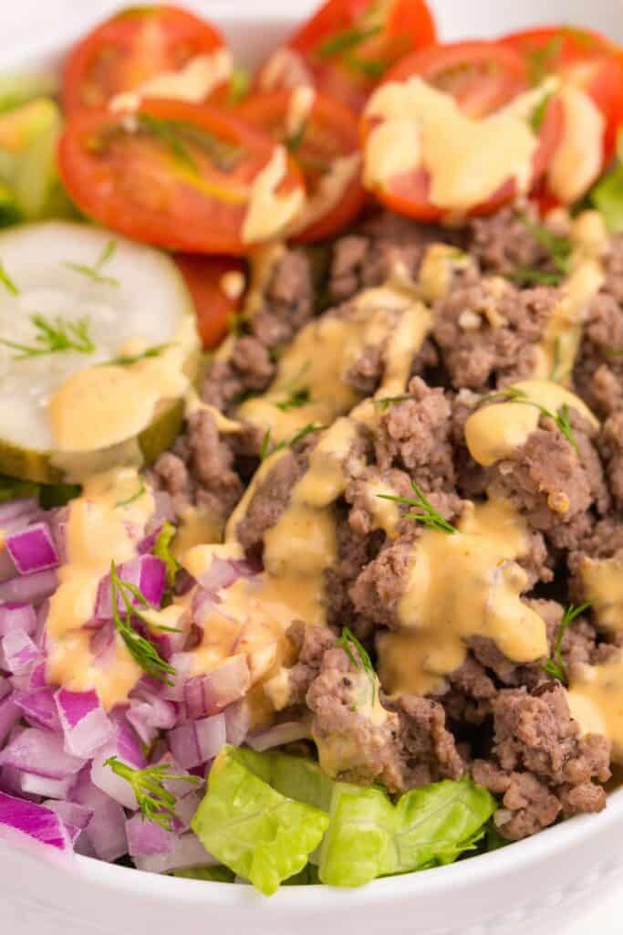 Burger bowl with burger sauce drizzled on top.