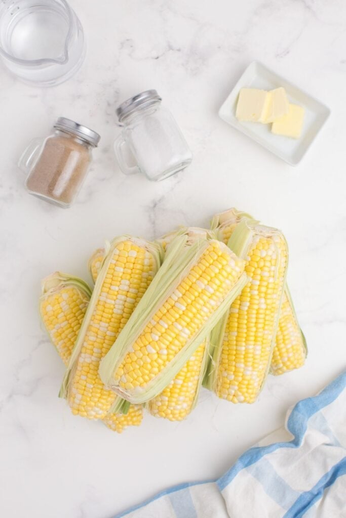 Ingredients for crock pot corn on the cob: water, salt, pepper, butter, and fresh corn on the cob.