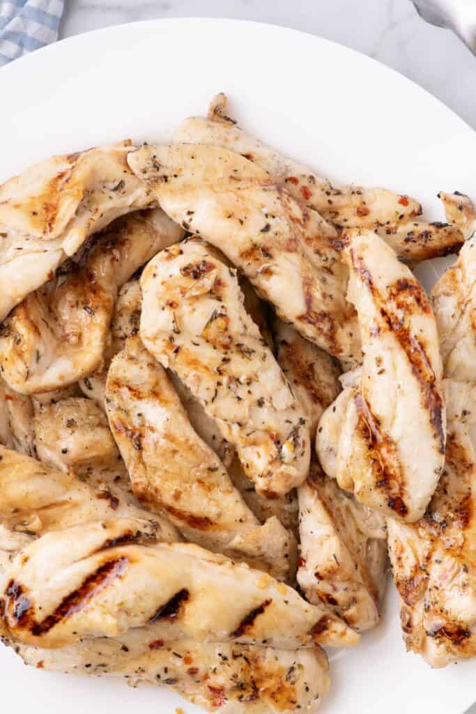 Grilled chicken tenders on a large dinner plate.