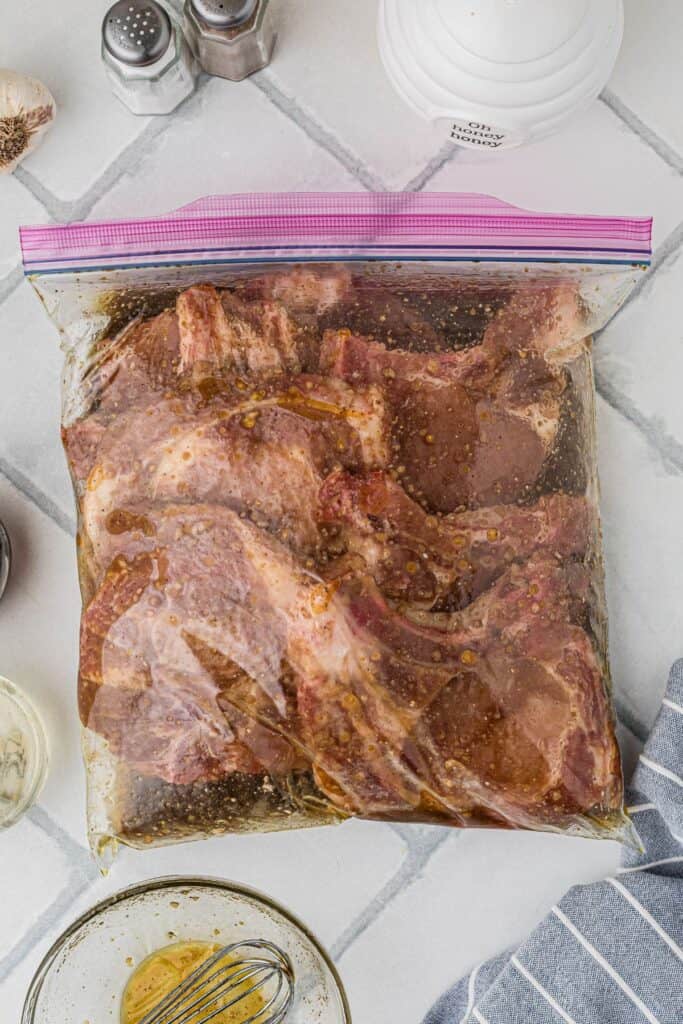 Pork chops marinating in a large zip top bag.