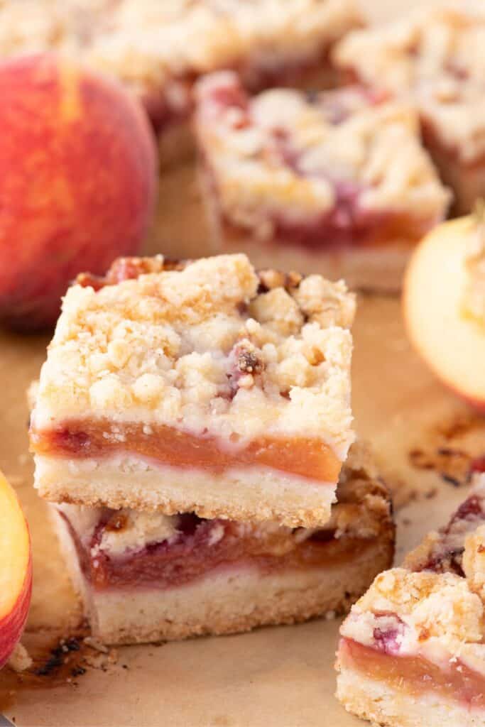 Sliced and stacked peach bars on a wooden cutting board.