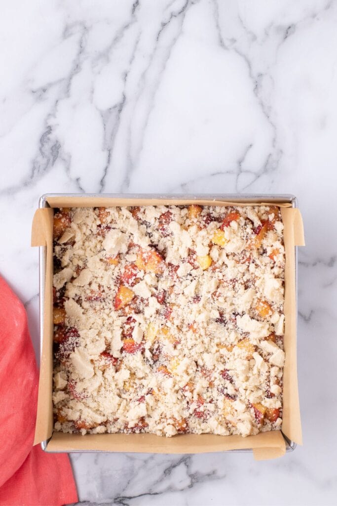 Unbaked bars in a parchment lined baking pan.