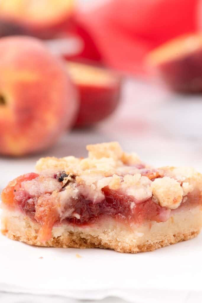 A peach bar with a bite taken out of it, on a white plate.